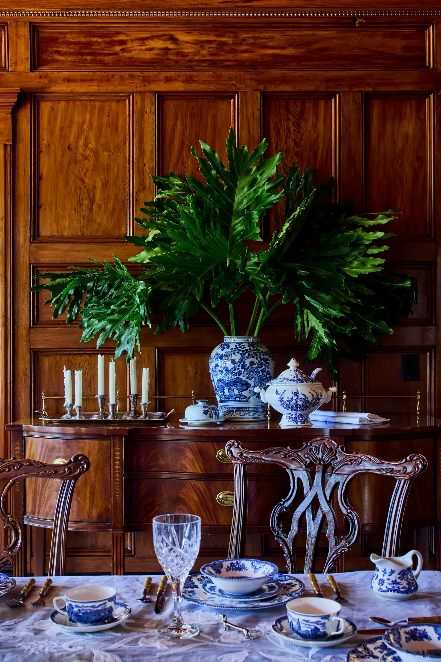 The dining room sideboard, blue and white china against paneled wood.
