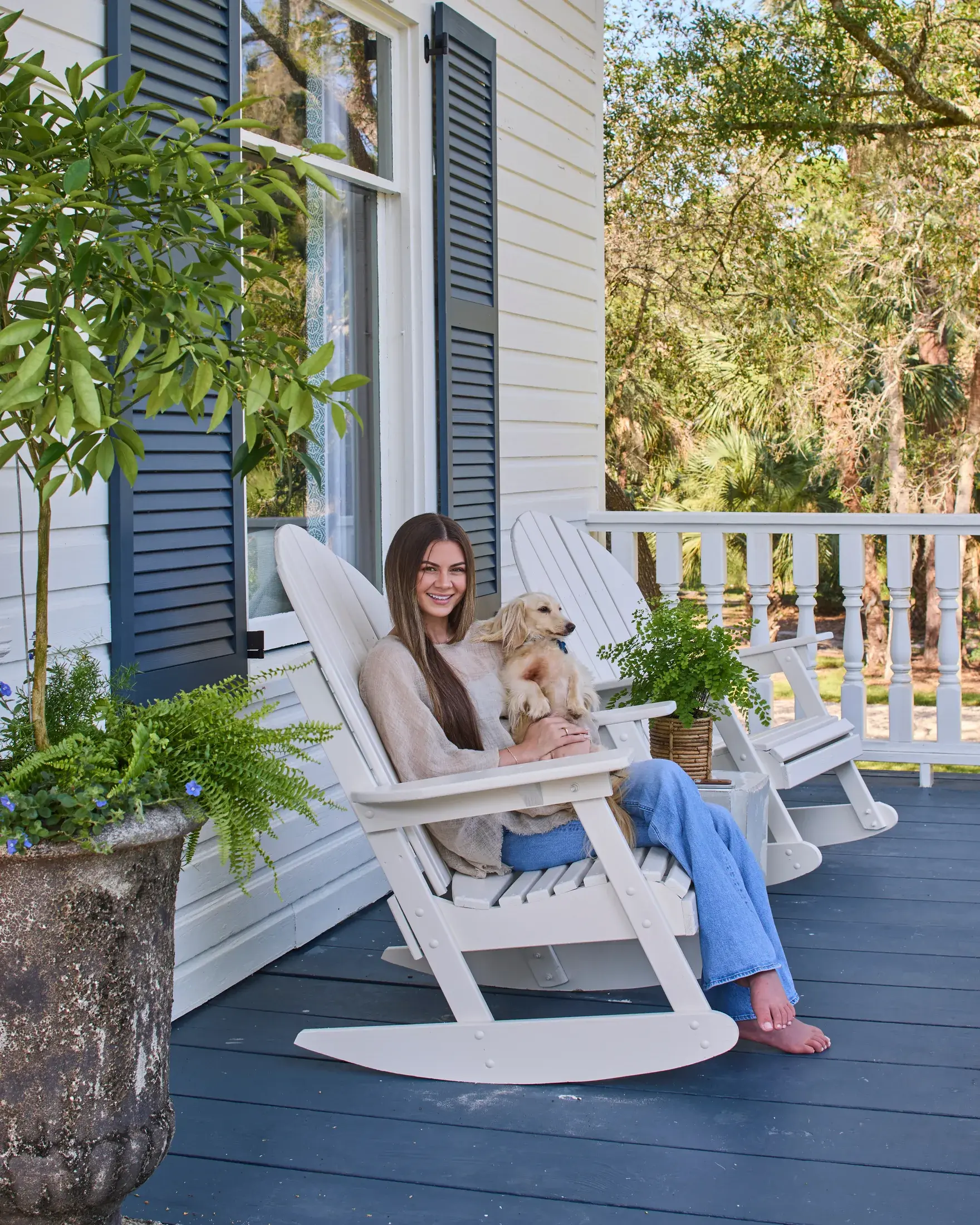 Megan McGill on the front porch with a dog on her lap.